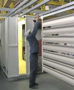 worker adjusting a rack of powder coated louvre components